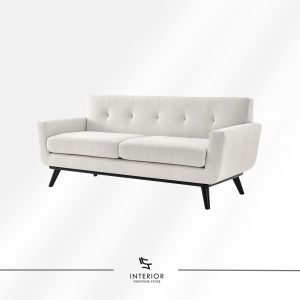 Modern upholstered sofa in soft beige fabric with clean lines, subtle button-tufted backrest, and dark wooden legs.