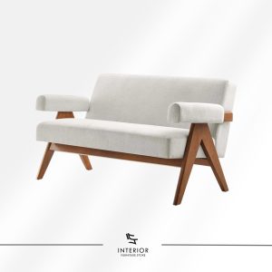 Upholstered lounge sofa with soft neutral fabric, featuring cylindrical armrests and angled solid wood legs for a warm mid-century inspired look.