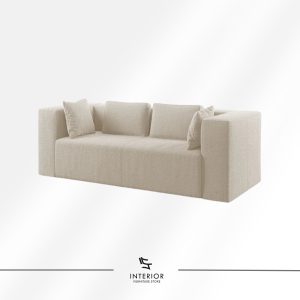 Modern upholstered sofa in soft off-white fabric with wide armrests, plush cushions, and a clean, block-style silhouette.