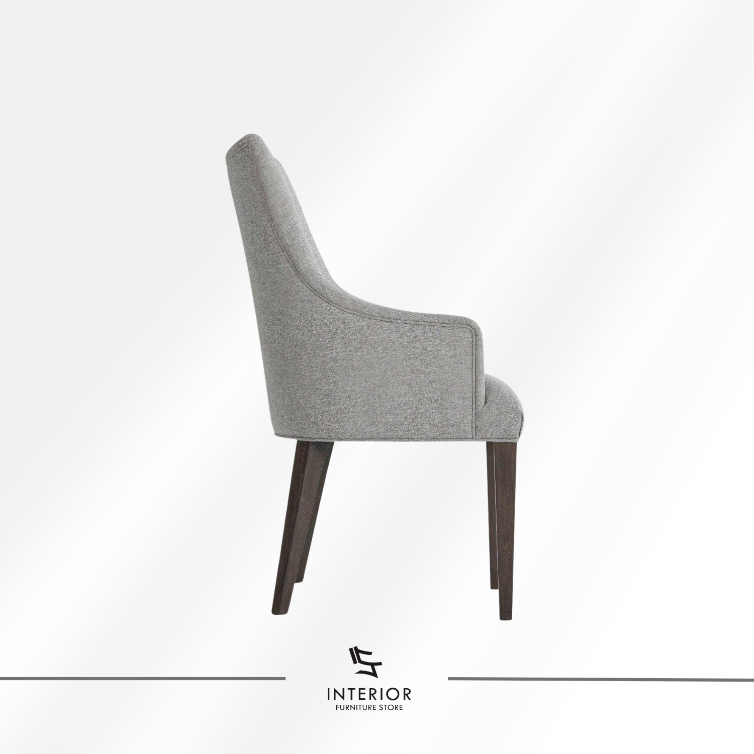 Upholstered dining chair with a light grey fabric finish, curved armrests, and dark wooden legs.