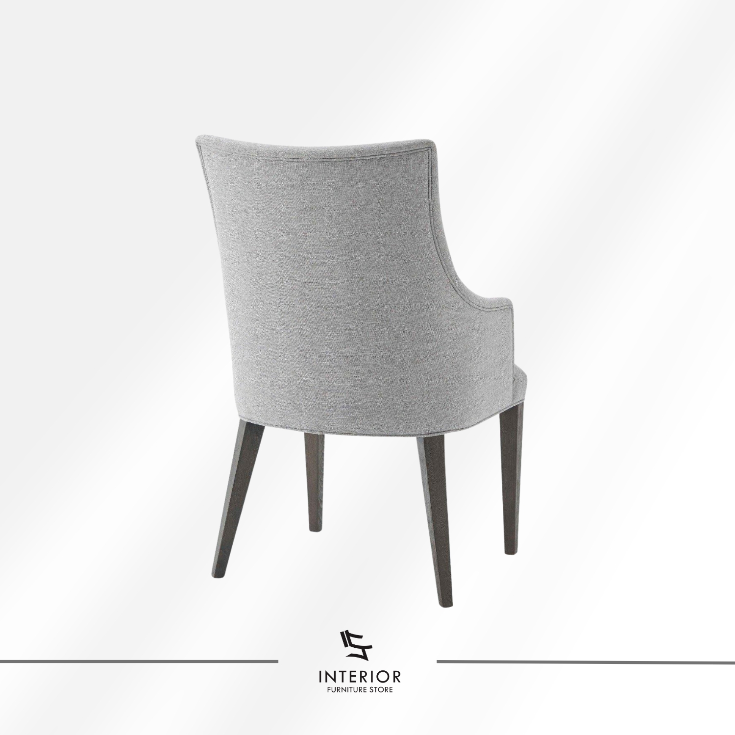 Upholstered dining chair with a light grey fabric finish, curved armrests, and dark wooden legs.