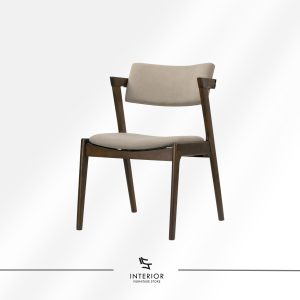 Dining chair with a gently curved upholstered backrest and seat, supported by a dark wooden frame and tapered legs.