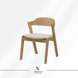 Light oak dining chair with a curved wooden backrest and a soft beige upholstered seat. The angled legs and clean lines create a modern, airy silhouette.
