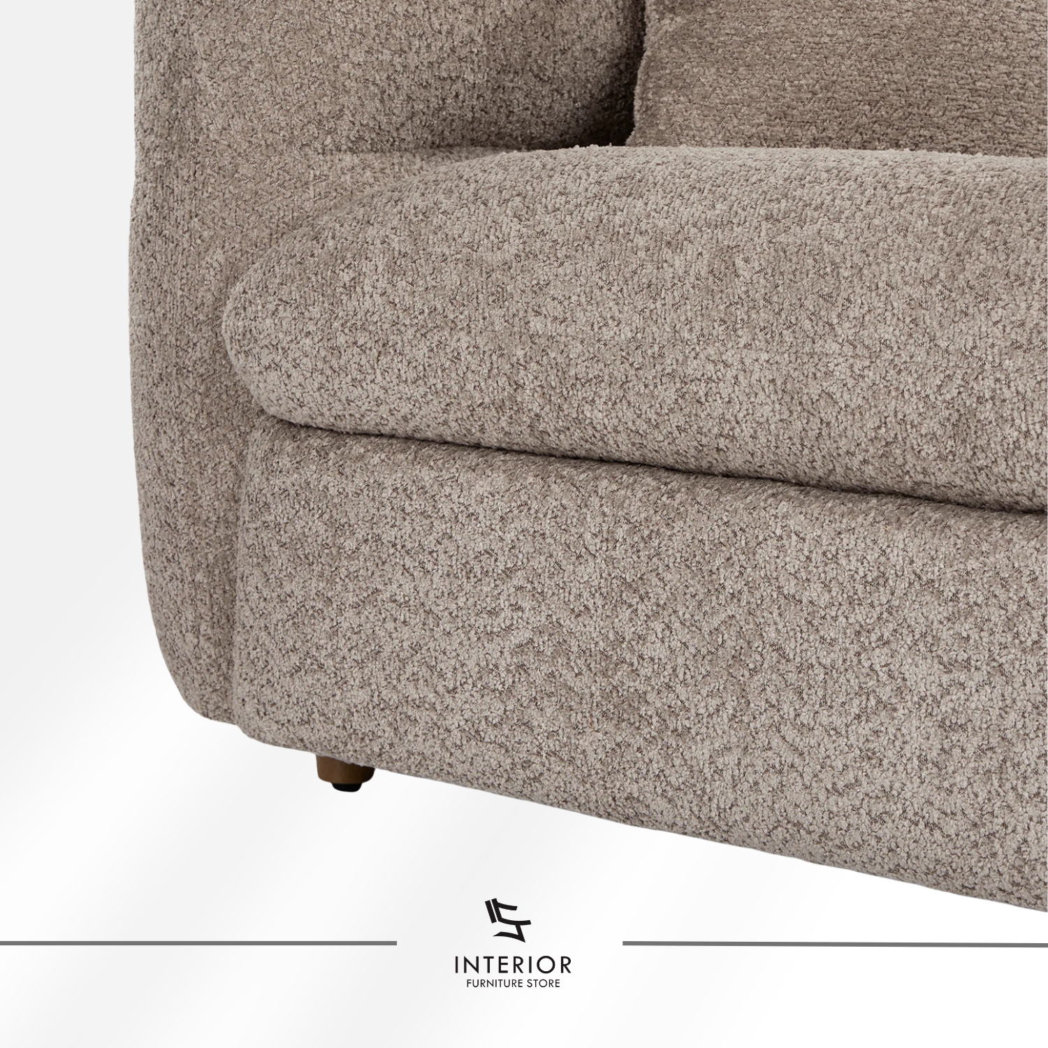 Curved upholstered sofa in warm beige fabric with a low backrest and rounded arms, complemented by two matching cushions.