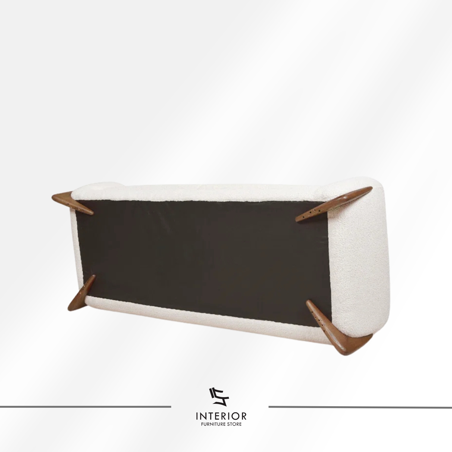 Curved modern sofa with textured cream upholstery and sculpted wooden side supports.