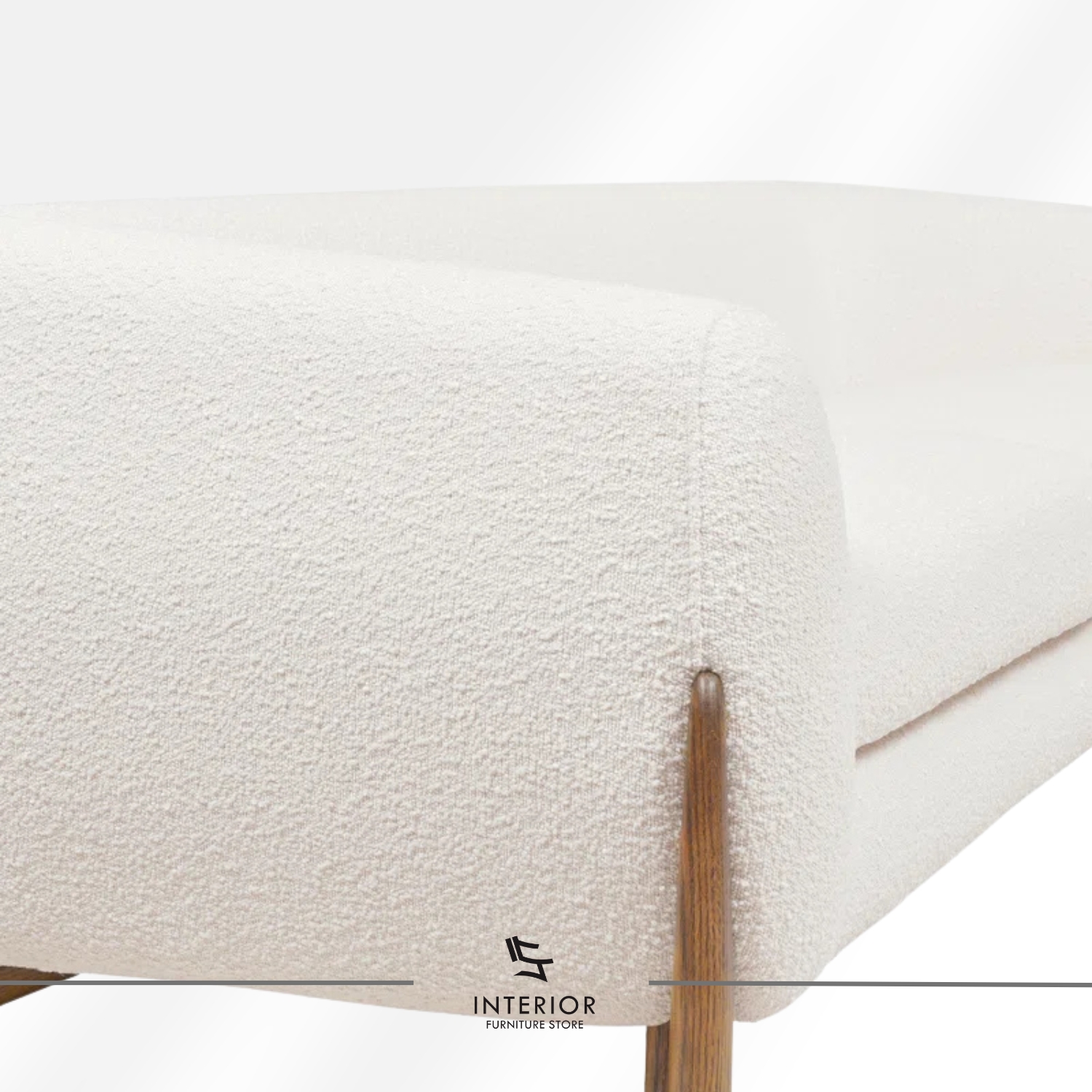 Curved modern sofa with textured cream upholstery and sculpted wooden side supports.