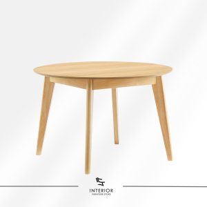 Round solid wood dining table with a smooth tabletop and tapered legs in a light natural finish.