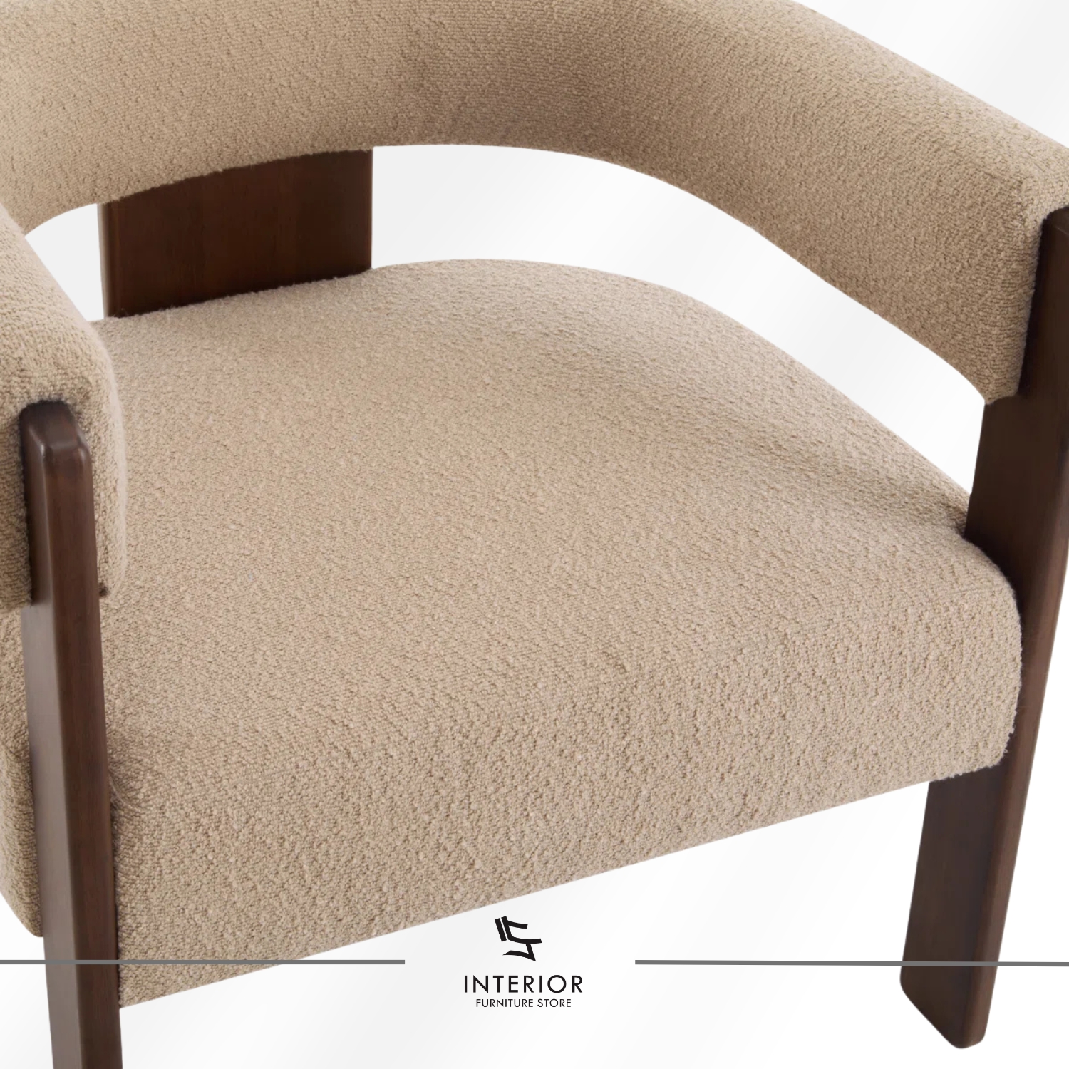A modern armchair with a curved upholstered backrest and seat in soft beige fabric, supported by a dark wooden frame with clean lines.